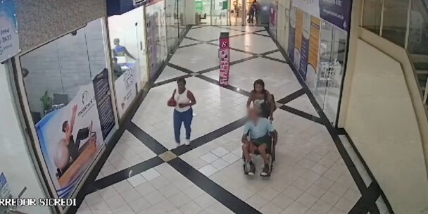 Mulher é flagrada em vídeo levando cadáver em cadeira de rodas para banco no Rio de Janeiro