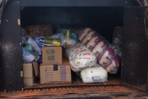 fila de moradores aguardando receber cestas básicas de supostos integrantes do CV